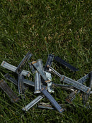 Pile of denim jeans on grass.